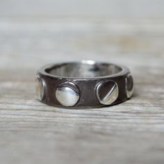 a close up of a ring on a wooden surface with two hearts in the middle