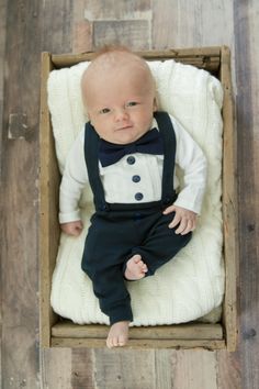 "This baby boy tuxedo bodysuit is perfect to dress your little guy up for a wedding, church, or a special occasion. Would make a perfect baby shower gift. A white pleated fabric bib collar is sewn to the front to make it look like a tuxedo shirt. A navy blue cotton bow tie is sewn along the neckline with a satin navy blue cumberbun along the waist. Cute navy blue 100% cotton suspender leggings, with front pockets complete the look. Can be made in the following sizes: Bodysuit sizing chart: 0-3 m Baby Boy Wedding Outfit, Baby Tuxedo, Wedding Outfit For Boys, Boy Christening Outfit, Boy Baptism Outfit, Toddler Suits, Boys Tuxedo, Outfit Baby Boy, Boy Dress