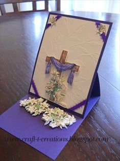 a greeting card with flowers and a cross on the front, sitting on a table