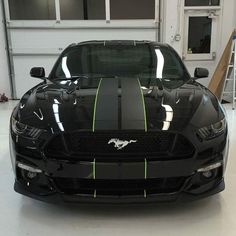 the front end of a black mustang with neon green stripes on it's hood