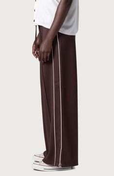 High-contrast piping at the sides enhances the sporty allure of track pants imagined in a super-wide-leg silhouette with footwear-flaunting slits at the hems. 31" inseam; 28" leg opening; 12 1/2" front rise; 16 1/2" back rise (size Medium) Drawstring waist 95% polyester, 5% spandex Machine wash, tumble dry Imported Black Owned/Founded Nordstrom x Nike: A curated lifestyle destination where fashion is the ultimate sport Nike Pants Brown, Wide Leg Track Pants, Honor The Gift, Brown Fits, Rollerball Perfume, Favorite Daughter, Contrast Piping, Loungewear Shorts, High Contrast