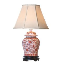 an orange and white vase with a lamp on it's base is shown in front of a white background