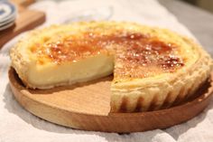 a cheesecake on a wooden platter with one slice cut out and ready to be eaten