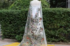 a dress on display in front of some bushes