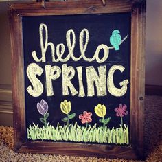 a chalkboard with the words hello spring painted on it in front of a carpeted floor