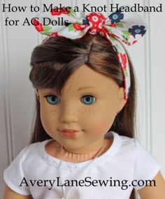 an american girl doll with blue eyes wearing a white shirt and red flowered headband