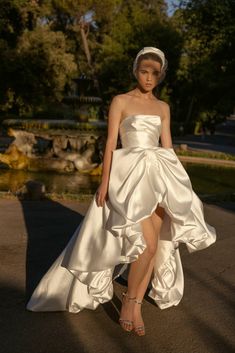 a woman in a white dress is posing for the camera