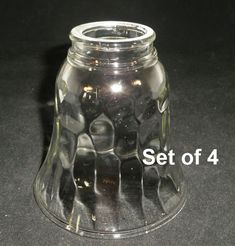 a clear glass vase sitting on top of a black table next to the words set of 4