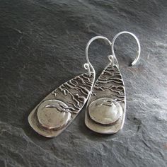 "A substantial and stunning pair of earrings in fine silver. These are 99.9% pure silver, pressed from my original carving. A little mystery with plenty of texture and shine. Each earring link is 1 3/8\" x 5/8\". The total length from the top of the earwire is 2\". Also available as a pendant, shown in the last photo: https://www.etsy.com/listing/126602245/artisan-fine-silver-pendant-moon-and?ref=shop_home_feat Thank you for visiting! Questions and custom requests are always welcome. To learn mo Personalized Silver Jewelry, Pmc Jewelry, Silver Metal Clay, Handmade Jewelry Findings, Hammered Jewelry, Silver Jewelry Box, Metal Clay Jewelry, Precious Metal Clay, Silver Jewelry Earrings