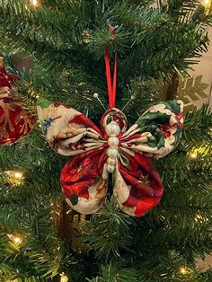 an ornament hanging from the top of a christmas tree with red, white and green bows