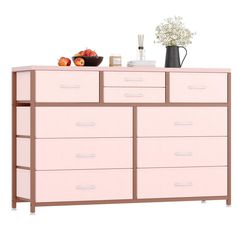 a pink dresser with drawers and fruit on top