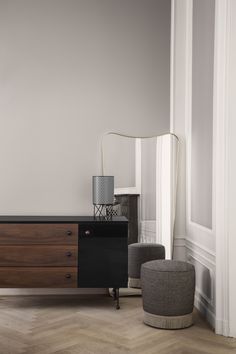 a living room scene with focus on the sideboard and footstool in the foreground