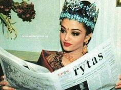 a woman wearing a tiara reading a newspaper