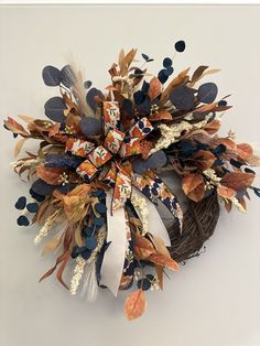 a wreath made out of dried leaves and feathers