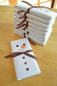 a stack of white napkins sitting on top of a wooden table next to a snowman