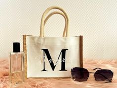 a bag, sunglasses and perfume bottle sitting on a fur surface