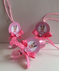 three pink minnie mouse hair clips with matching tags and bows on white table top next to each other