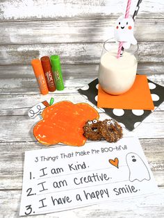 a glass of milk and some candy are sitting on a wooden table next to an orange napkin