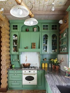 a kitchen with green cabinets and marble counter tops