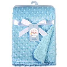 a blue blanket with a white bow on it and a tag hanging from the front