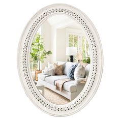 an oval mirror reflecting a couch in a living room