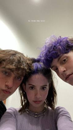 three young people with purple hair standing in front of a mirror