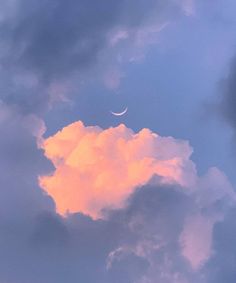 the moon is seen through some clouds on a cloudy day