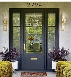 a blue front door with two planters on either side and the number 2784