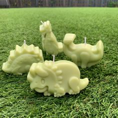 three candles shaped like elephants sitting in the grass