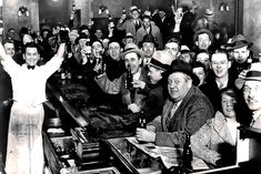 a group of men and women sitting at a bar with bottles in front of them