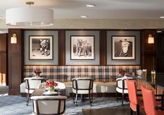 a room with chairs, tables and pictures on the wall behind them in a hotel lobby