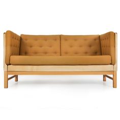 a tan couch sitting on top of a white floor