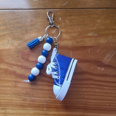 a pair of blue and white sneakers with tassels are on a wooden table