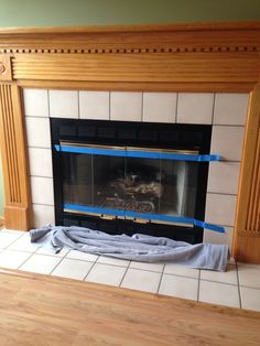 a fireplace is being worked on with blue tape