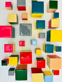 colorful cubes are arranged on a white wall