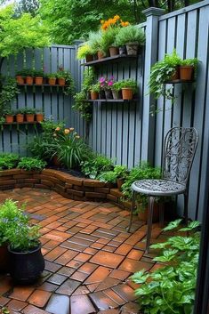 an outdoor patio with potted plants on the wall and a bench in the middle