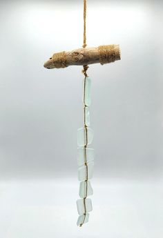 a piece of wood and glass hanging from a rope