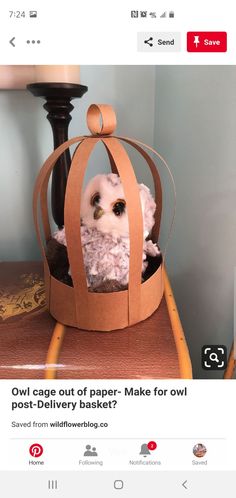 an owl in a paper bag sitting on top of a table