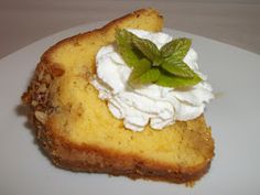 a piece of cake with whipped cream and mint on top is sitting on a white plate