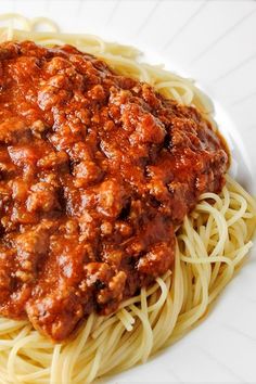 a white plate topped with spaghetti and meat sauce