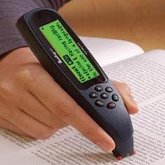 a person is holding an electronic device in their hand and reading a book with it's cover open