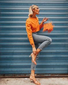 a woman standing in front of a blue garage door holding an orange piece of string