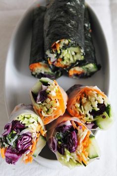 an assortment of food items displayed on a white plate, including sushi and rice rolls