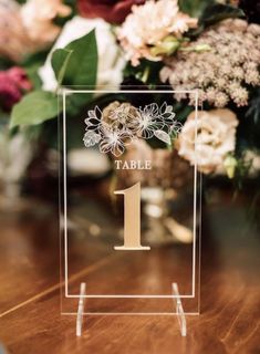 a table number with flowers in the background