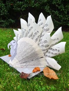 a paper fan sitting in the grass with music notes on it's back end