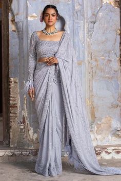 Grey georgette saree with self and silver bead work , sequins and crystals with feather fringes. Paired with full sleeve organza blouse and petticoat.
Components: 3
Pattern: Embroidered
Type Of Work: Sequin, Bead, Crystals
Neckline: Square
Sleeve Type: Full
Fabric: Saree: Pure Georgette and Blouse: Art Organza, Petticoat: Shantoon
Color: Grey
Other Details: 
Back tassel tie-up
Bead and crystal work
Occasion: Wedding,Reception - Aza Fashions Saree With Full Sleeves, Sequinned Saree, Full Sleeves Blouse, Full Sleeves Blouse Designs, Crystal Work, Silver Blouse, Pure Georgette Sarees, Sequin Saree, Grey Saree