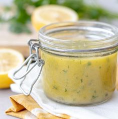 a glass jar filled with lemon cucumber sauce on top of a white napkin