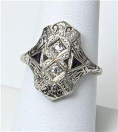 - Vintage 14k White Gold Art Deco Diamond Ring- Gorgeous details on face and shoulders- Ring size 8.25- Diamonds each measure 2mm in diameter- Ring face measures .8" tall by .72" wide and .24" deep- Wonderful vintage condition, signed / marked "BE"  "ML"- Weighs 4.2 gramsA wonderful antique ring! 14k Gold Art Deco Jewelry, Art Deco White Gold Rings Stamped 14k, White Gold Art Deco Rings Stamped 14k, Art Deco 14k White Gold Ring, Art Deco Silver Diamond Ring In 14k Gold, Silver 14k Gold Art Deco Diamond Ring, Art Deco Platinum Ring Jewelry, Platinum Art Deco Ring Jewelry, 14k White Gold Ring With Intricate Design