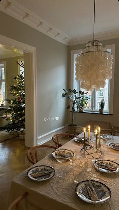 a dining room table with plates and candles on it