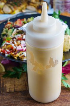 a close up of a plastic cup on a table with food in the back ground